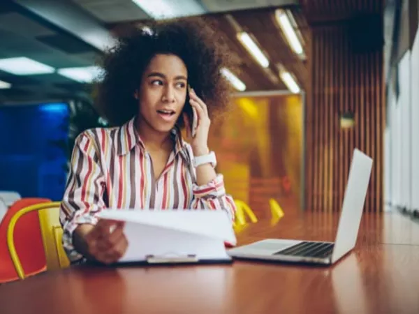 Woman calling on cell phone to find out if U-Haul will rent a trailer with a Ford Explorer.
