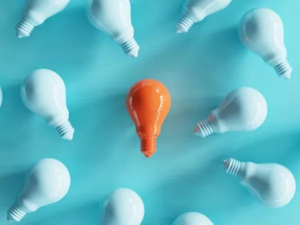 Image with white lightbulbs and an orange bulb in the middle, representing U-Haul discount codes.