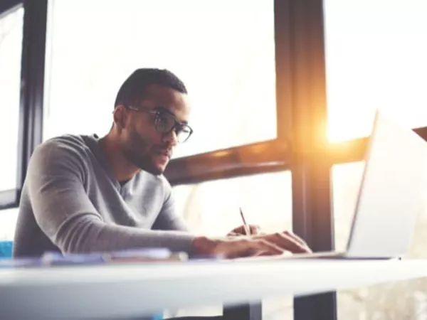 Man looking on a laptop to learn about U-Haul rental requirements.
