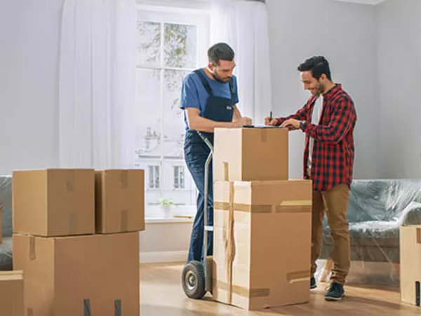Man looking at paperwork from moving crew to determine the cross country moving costs.