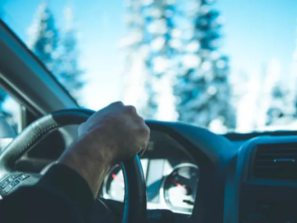 Person driving in snow and ice during a long-distance move.