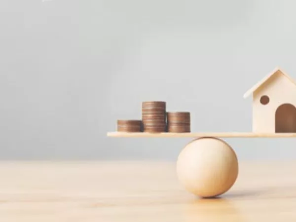 A scale balancing the household goods shipping costs with a home.