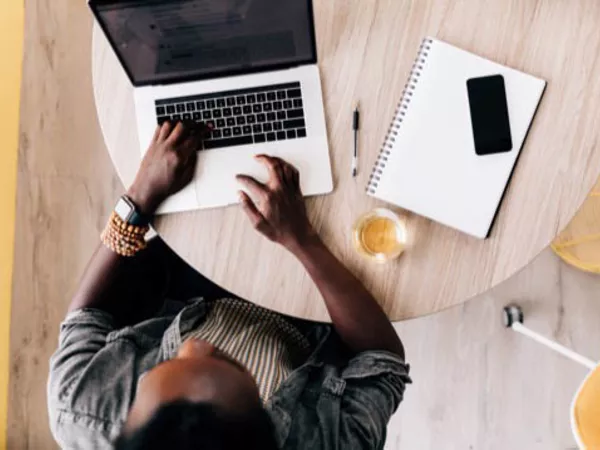 Man planning a move in advance using computer, phone, paper and pen.