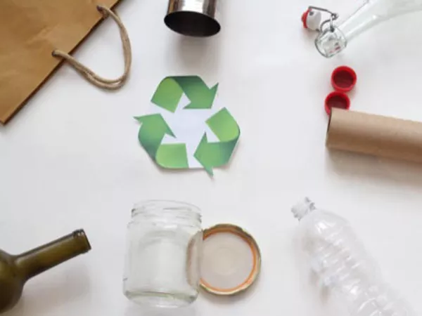 Different recyclable items like paper, plastic bottle, glass and the recyclable symbol in the center.