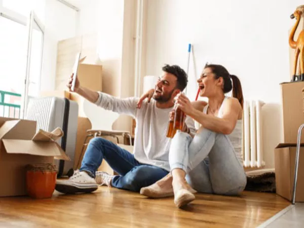 Couple taking a selfie among their moving boxes to let people know they're moving.