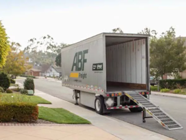 An empty U-Pack moving trailer sits on a residential street with the ramp fully extended after getting a certified empty weight ticket.