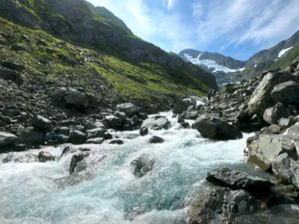 Alaskan river with the mountains and blue sky, a view seen after moving to Alaska.