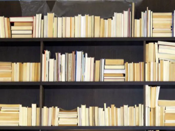 Bookshelf lined with books to be moved.