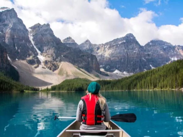 Person riding in a canoe on an Alaskan lake, free after moving to Alaska.