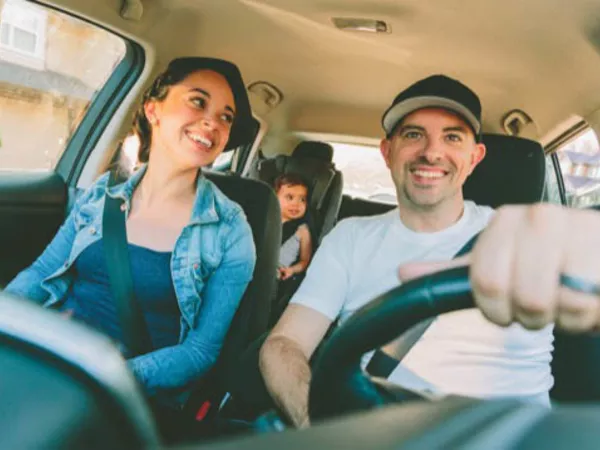 Family laughing in the car playing a road trip game.