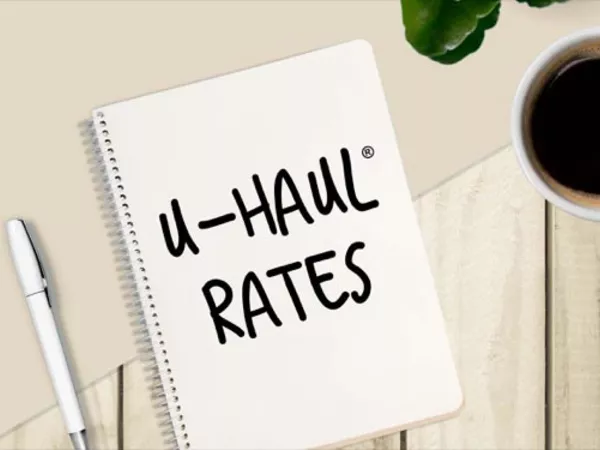 Notepad with "U-Haul Rates" written on it, sitting next to a cup of coffee.
