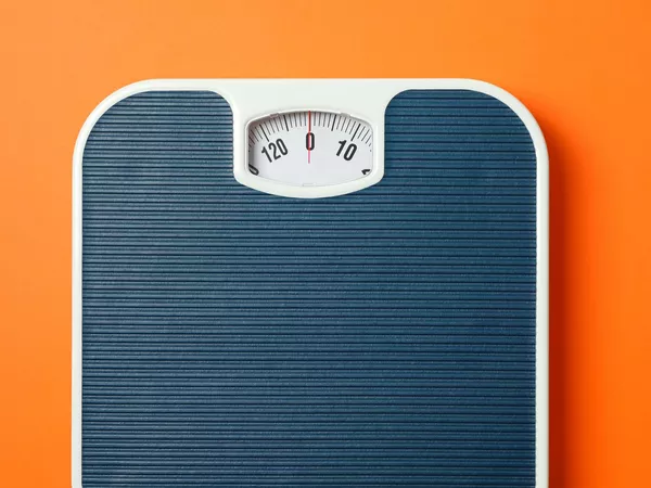 Scale, reading 0, on orange background, showing how you could measure moving weight guidelines.