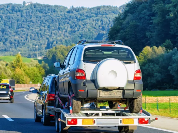A car being towed on a car trailer during a long-distance move.