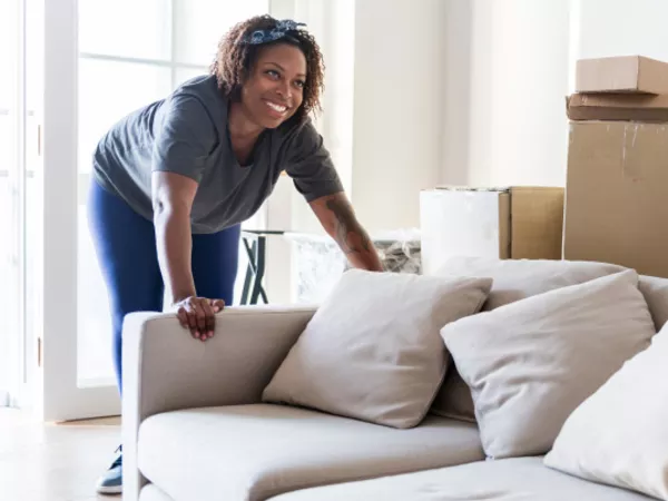 Woman moving boxes, furniture and other essential supplies into her new apartment.