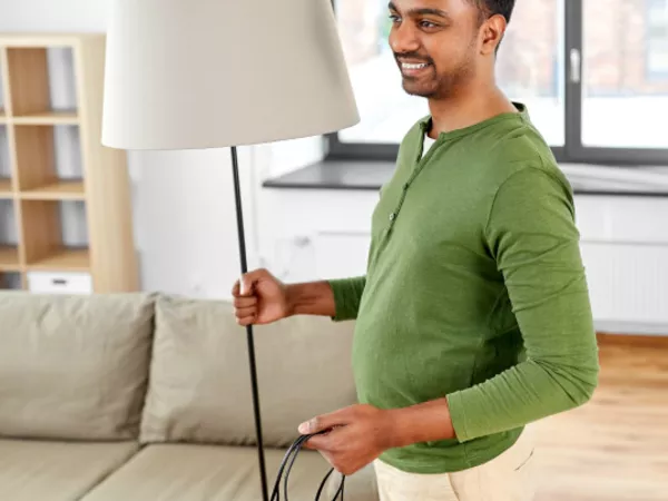 Man prepares to pack a lamp for moving.