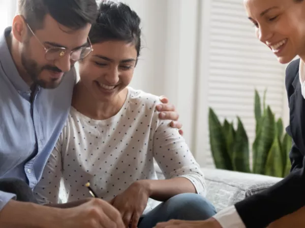 Couple signs apartment lease while landlord explains how to get their deposit back after moving.