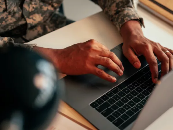A person using a laptop to research ways to pay for a military move.