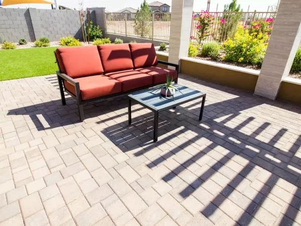A back porch with patio pavers and an outdoor couch and table.