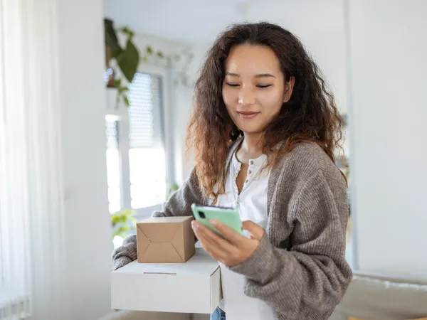 A woman uses her smartphone to access U-Pack’s digital technology to manage her move.