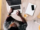 Man planning a move in advance using computer, phone, paper and pen.