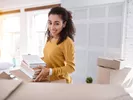 Female student packing books for college using a college packing checklist.