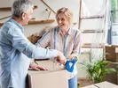 Couple packing moving boxes together doing a self-move.