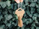 Person holding keys against a wall of ivy.