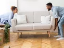 Woman and man picking up a couch preparing to ship furniture to another state.