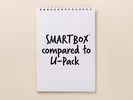 notebook sitting on a table with writing that says “SMARTBOX compared to U-Pack”