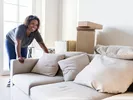 Woman moving boxes, furniture and other apartment essentials into her new apartment.