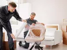 Two movers wrapping a chair for a full-service move.